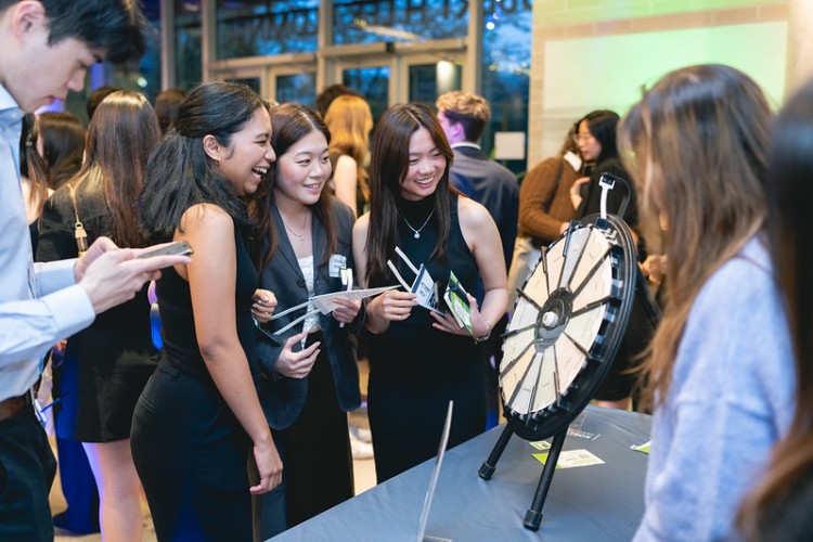 A group of Spring 2024 Sauder grads excitedly spinning a prize wheel at the 2024 Commerce Last Lecture event